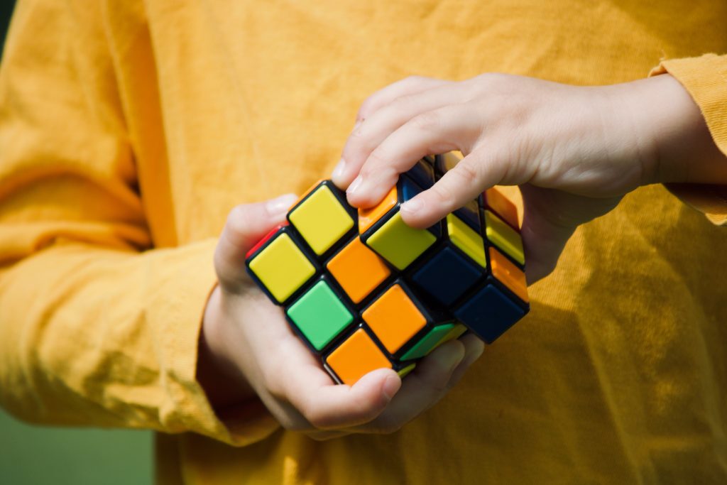 midsection-boy-playing-with-puzzle-cube